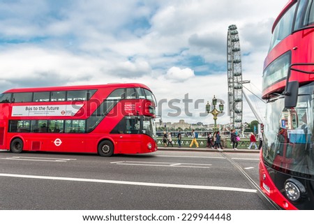 LONDON - AUGUST 27, 2014: Buses and tourists cross the Westminster Bridge in front of the London Eye, Europe's tallest Ferris wheel on the South Bank of the River Thames, a famous tourist attraction