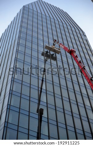 MILAN,ITALY-DECEMBER 5: worker who cleans the windows in a skyscraper on December 5, 2013 in Milan Italy