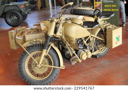 MILAN, ITALY - NOV 1: Old motorcycle military, Exhibitor sitting in his stand at Militalia, exhibition dedicated to militaria collectors and military associations on November 1, 2014 in Milan.