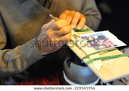 MILAN, ITALY - NOV 1: Scoring Knife, Exhibitor sitting in his stand at Militalia, exhibition dedicated to militaria collectors and military associations on November 1, 2014 in Milan.