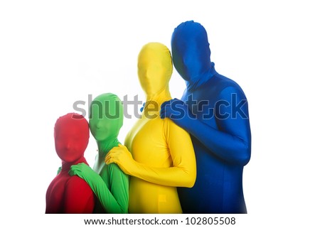 A family of four in bright, colorful body suits.  The Dad is wearing blue, the Mom is wearing yellow and the two children are wearing red and green.