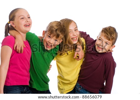 A group of four young kids wearing colorful shirts and having fun.