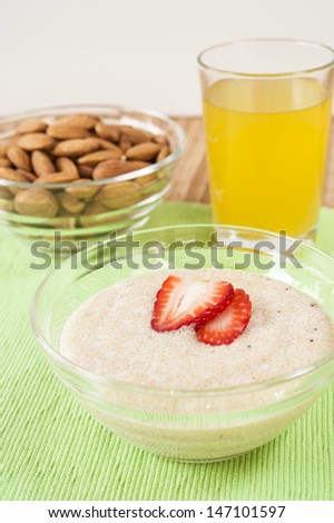 Dish of Amaranth and yogurt with raw almonds and a glass of orange juice