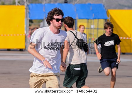 BENICASIM, SPAIN - JULY 19: A boy with an Arctic Monkeys band shirt, runs to catch the first row at FIB (Festival Internacional de Benicassim) 2013 Festival on July 19, 2013 in Benicasim, Spain.