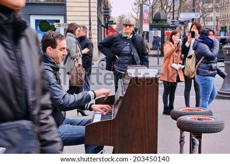 PARIS - MAR 1: A talented homeless musician plays the piano in the street to earn some money on March 1, 2014 in Paris, France.