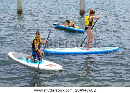 BARCELONA - JUN 28: People doing Stand up paddle surfing, or boarding (SUP), at LKXA Extreme Sports Barcelona Games on June 28, 2014 in Barcelona, Spain.