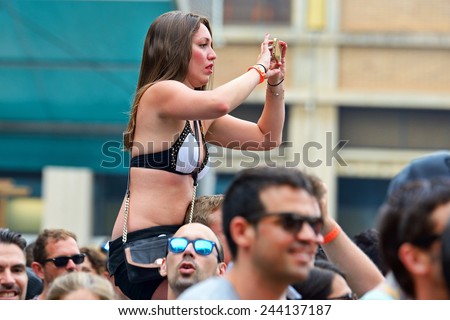 BARCELONA - JUN 13: A woman taking a picture with her phone from the audience at Sonar Festival on June 13, 2014 in Barcelona, Spain.
