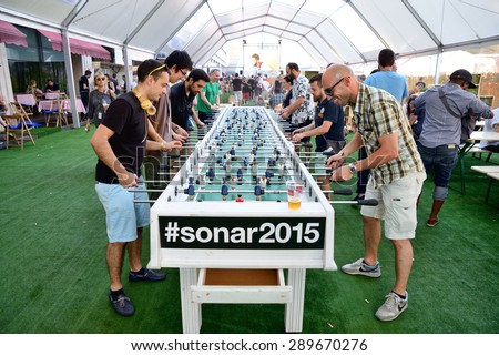BARCELONA - JUN 19: People play in a extra large foosball (also know as table soccer and table football)  at Sonar Festival on June 19, 2015 in Barcelona, Spain.
