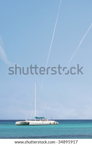 Catamaran in Caribbean sea on blue sky background