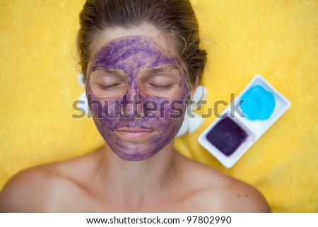 Young woman in the tropical spa making face mask