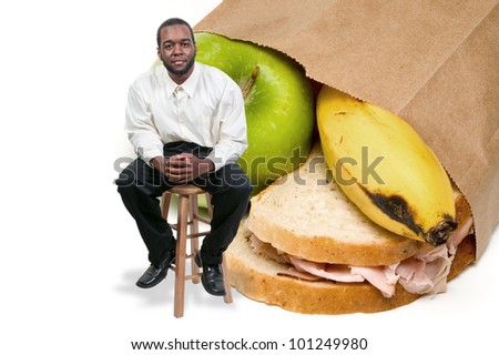 Handsome black African American man with a nutritious lunch in a brown bag.