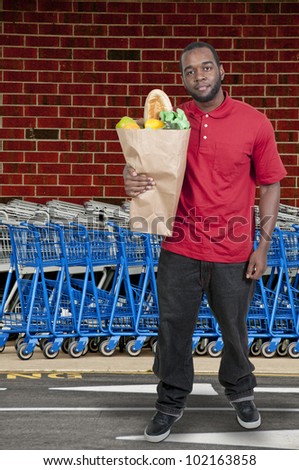 Handsome young man doing his grocery shopping