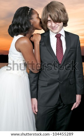 A young beautiful black African American woman whispering a secret to a young man