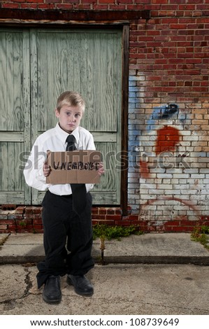 Handsome little boy holding up an unemployment sign
