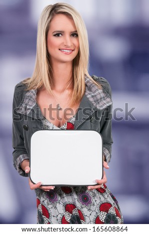 Beautiful young woman holding up a blank sign
