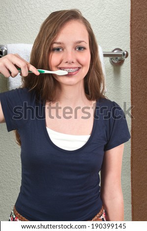 Beautiful teenage woman practicing good oral dental care by brushing her teeth