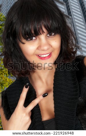 Beautiful young woman flashing a gang sign with her hand
