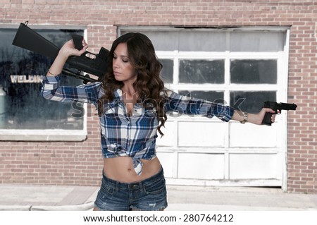 Beautiful young woman soldier with a pistol and rifle