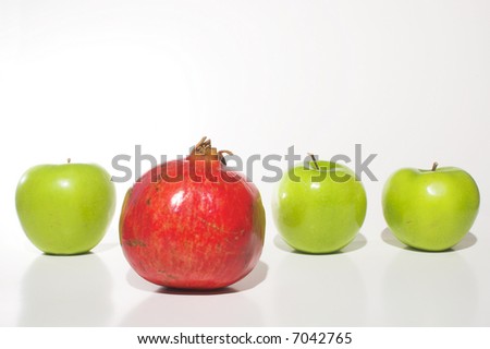Several Granny Smith apples and a delicious pomegranate.