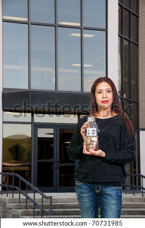 A beautiful Hispanic Latino woman holding her retirement account of coins in a milk bottle