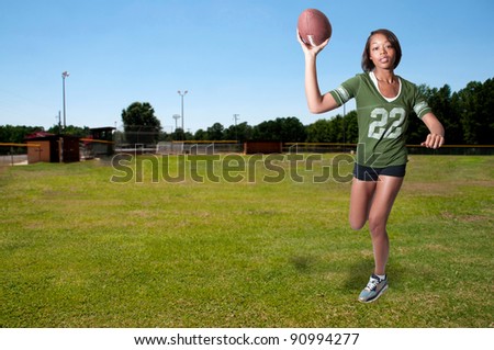 Beautiful black African American woman playing football