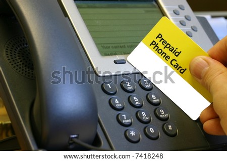 Prepaid Phone Card in Man\'s Hand at a Telephone