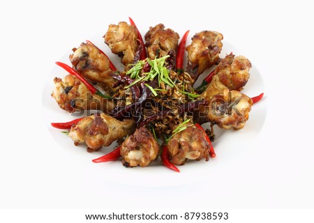 Spicy herb fried chicken wings in food dish.