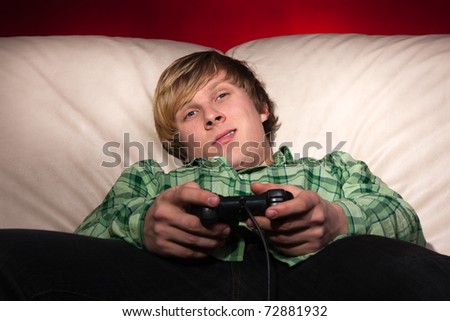young man playing video games on red background