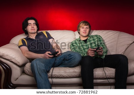 two guys playing video games on red background