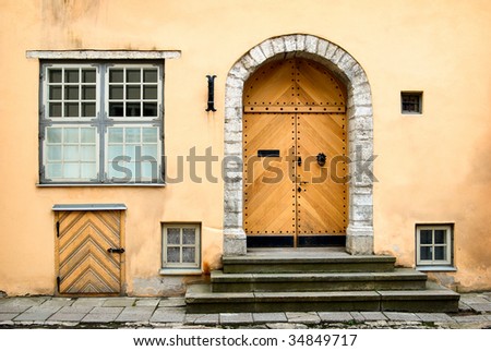 Detail of old building facade with arch doors and windows in a town.