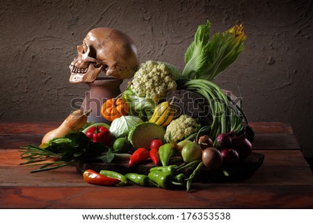 Still life art photography on raw mixed vegetables with skull
