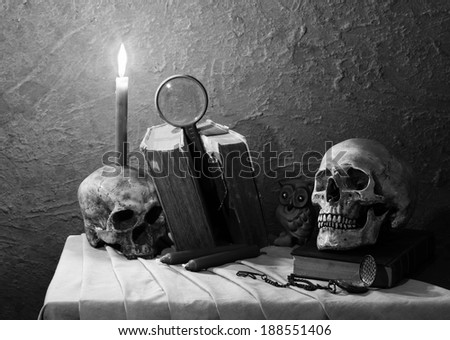 Still life art photography with skull on old book and candle on ruin skull black and white version