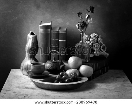 Still life art photography with books fruits roses on marble table black and white version