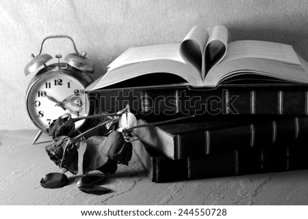 Still life art photography love concept with vintage book pages love heart sign on grunge black and white version