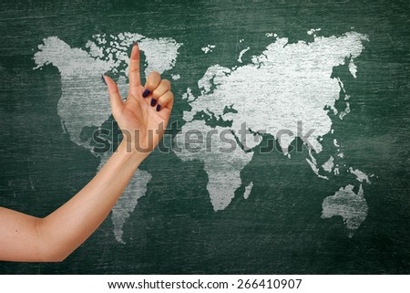 businesswoman hand pointing index on classroom media continents over green board