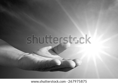 human hand praying over blur bright environment