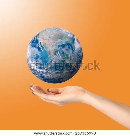 Human hands palm up with global image over orange shade Elements of this image furnished by NASA