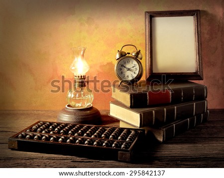 Still life art photography wisdom concept with alarm clock books oil lantern lamps wood abacus on vintage background environment
