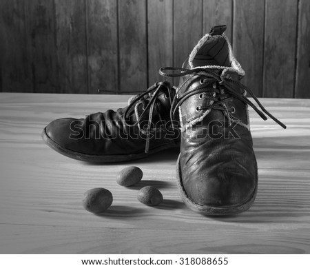 Old muddy shoes vintage style on wood floor and wood panel black and white version