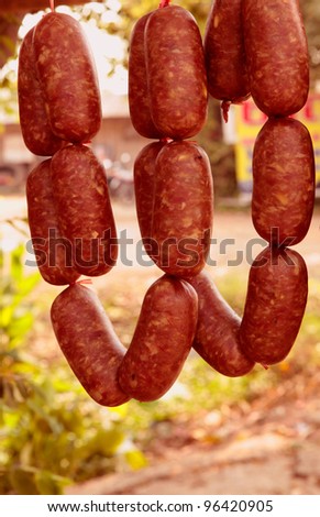 Home made meat salami sausage at street market hanging in line under sunlight to make good tasty,Korat,Thailand.