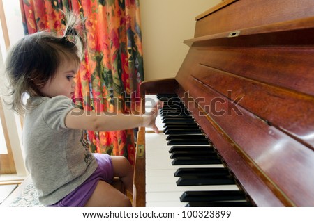 Little sweet girl plays piano. Concept photo of child play music, children, education,  music , sound, piano, art,  creativity ,imagination.