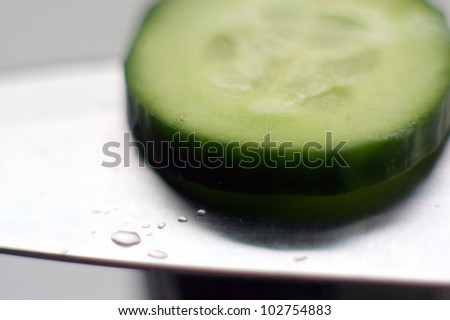 Cucumber slice on sharp knife. concept photo of food, sharp, sharpness, cutting edge, slice, cut, cutting, healthy lifestyle.