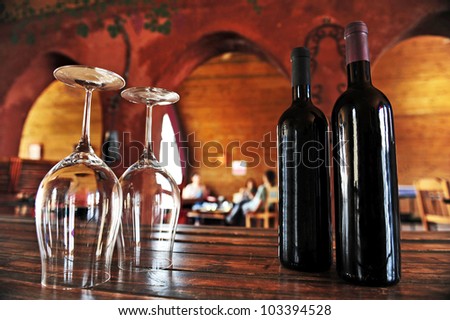 Wine bottles and wine glasses in a vineyard.