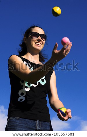 Young woman juggler is juggling balls. concept photo of flexibility, success, skill and control.