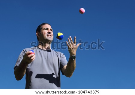 Young man juggler is juggling balls.concept photo of flexibility, success, skill and control.