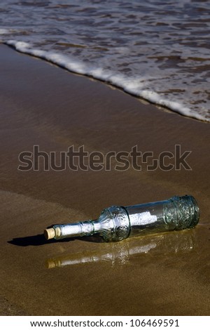 Message in a bottle washed ashore on a beach. concept photo of message in bottle