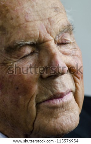 Portrait of a tired old man in his 90\'s, isolated on white background.