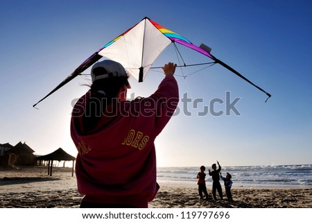 ASHDOD - DECEMBER 19:People flying a kite on the beach on December 19 2009 in Ashdod, Israel. Kite flying is one of the fastest growing sports in the world.