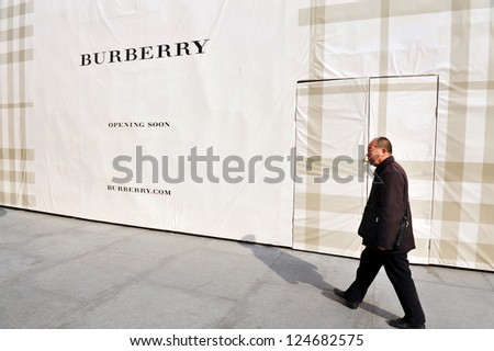 BEIJING - MARCH 11:Chines man walks besid a new Burberry shop on Mar 11 2009 in Beijing China.China is the second largest importer of goods in the world.