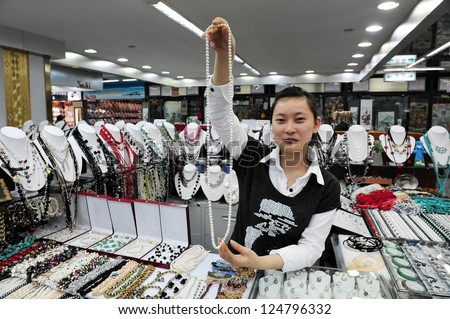 BEIJING-MARCH 14:Chinese woman sales pearl necklace at Beijing Pearl market on Mar 14 2009 in Beijing, China.It\'s a famous mega-market that attracts many tourists looking for China\'s well known pearls